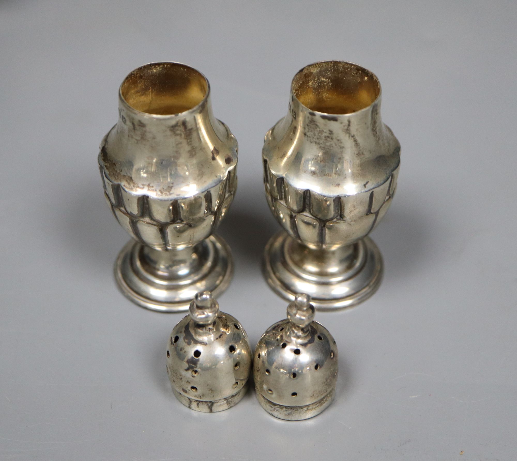 A George V silver sugar bowl and cream jug, London 1935 and a pair of Edwardian silver salt and pepper pots, London 1905,